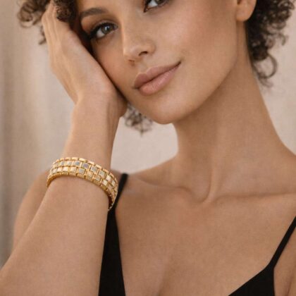 Złota bransoletka damska na ręce modelki, luksusowa biżuteria