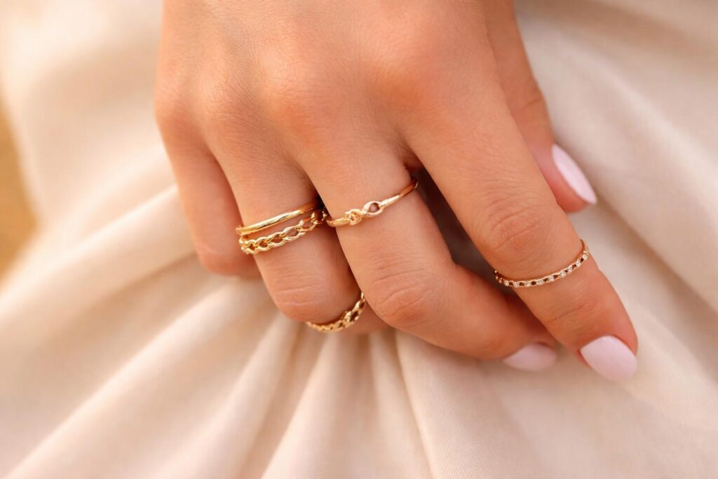 Delikatna złota biżuteria na dłoni na jasnym, eleganckim tle
